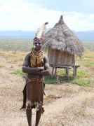 Frau des Karo - Volkes - Im Hintergrund eine Versorgungshütte