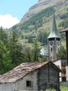 Kirche in Zermatt und altes Haus mit Steinplatten auf dem Dach