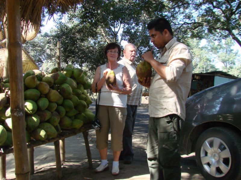 Reiseleiter spendiert eine Runde Kokosnüsse